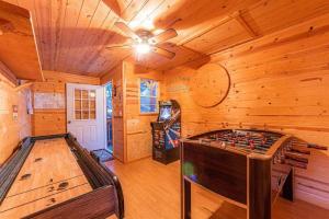 Cabin #5 Black Bear - Pet Friendly - Sleeps 6 - Playground & Game Room في بايسون: غرفة كبيرة مع طاولة ألعاب في كابينة