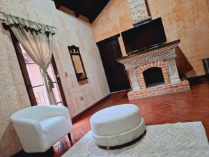 a living room with a fireplace and a tv at Hotel Boutique Casa Del Ángel in Antigua Guatemala