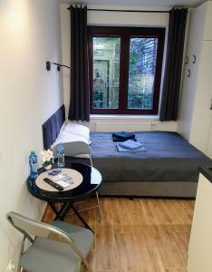 um quarto com uma cama, uma mesa e uma janela em Apartamenty u Portera w Śródmieściu em Gdynia