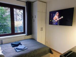 um quarto com uma cama e uma televisão na parede em Apartamenty u Portera w Śródmieściu em Gdynia