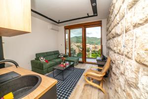 a bathroom with a couch and a sink in a room at Apartman Roccia in Trebinje +2 photos