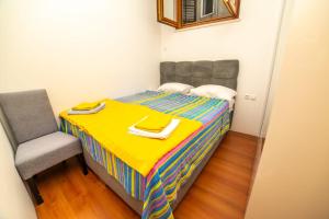 a small bedroom with a bed and a chair at Apartman Roccia in Trebinje