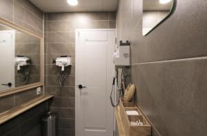 baño con puerta blanca y espejo en Blueboat Hostel Jeonju en Jeonju