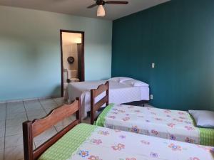1 Schlafzimmer mit 3 Betten und einem Deckenventilator in der Unterkunft Casa di Angeli in Barretos