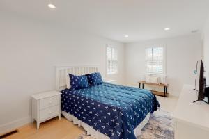 Schlafzimmer mit einem Bett mit blauer Decke in der Unterkunft Peace & Quiet on ACK in Nantucket