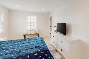 1 dormitorio con cama y vestidor con TV en Peace & Quiet on ACK, en Nantucket