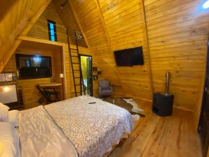 una camera con un letto in una cabina di legno di Cabana Nova Petrópolis a Nova Petrópolis