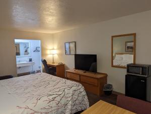 um quarto de hotel com uma cama e uma televisão em Henry's Fork Inn em Saint Anthony