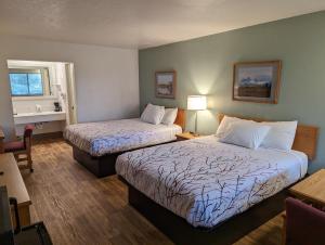 a hotel room with two beds and a window at Henry's Fork Inn in Saint Anthony