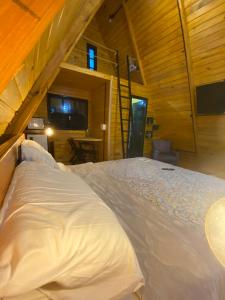 um quarto com uma cama num chalé de madeira em Cabana Nova Petrópolis em Nova Petrópolis