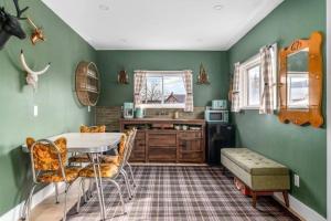 a kitchen with green walls and a table and chairs at Urban Cabin - Downtown Picton in Picton