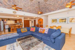 a living room with a blue couch and a kitchen at Yellow Rose in Puerto Peñasco