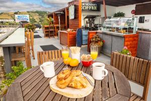 a table with a plate of croissants and glasses of orange juice at Inn At Avila Beach in Avila Beach