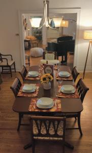uma mesa de jantar com cadeiras e uma mesa com pratos e copos em Historic Oakpark Home 