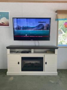 uma televisão de ecrã plano em cima de um centro de entretenimento branco em Beaver Lake Resort Site #36 em Lake Cowichan