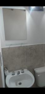 ein Badezimmer mit einem weißen Waschbecken und einem WC in der Unterkunft Posada Atardeceres in Puan