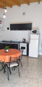 a kitchen with a table and a white refrigerator at Posada Atardeceres in Puan