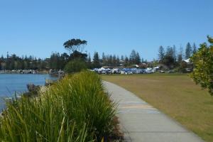 a sidewalk next to a park next to a body of water at DELUXE Escape! Central, NEW & Spacious 3 Bed in Yamba