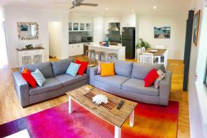 a living room with a couch and a table at DELUXE Escape! Central, NEW & Spacious 3 Bed in Yamba