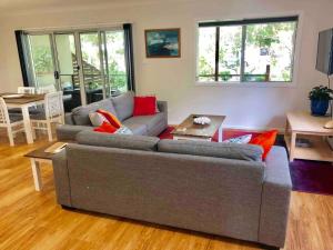 a living room with a couch and a table at DELUXE Escape! Central, NEW & Spacious 3 Bed in Yamba