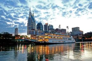 um navio de cruzeiro ancorado na água com uma cidade em Heart of Downtown/Walk to BROADWAY & THE ACTION/BARS/Music Venues/Honky Tonks! em Nashville