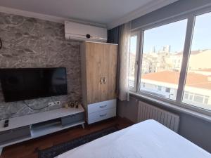 een slaapkamer met een flatscreen-tv aan een stenen muur bij FIRAT's Home in Istanbul
