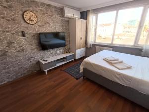 een slaapkamer met een bed en een flatscreen-tv bij FIRAT's Home in Istanbul
