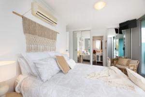 una camera bianca con un grande letto e un soggiorno di Shores 103 a Forster