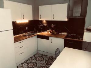 a kitchen with white cabinets and a sink and a table at Helios house in Antalya