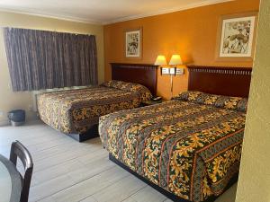 Habitación de hotel con 2 camas y 2 lámparas en Kings Rest Motel, en Lemoore