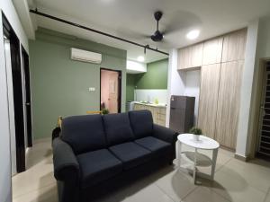 a living room with a blue couch and a table at Pacific Place Ara Damansara LRT Pool Parking Kitchen By Kenangan Homes in Petaling Jaya