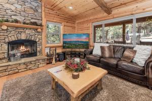 a living room with a couch and a fireplace at Paradise Peak - One of kind and breathtaking log cabin with Hot Tub and Game Room! in Big Bear Lake