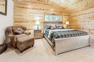 a bedroom with a bed and a chair in a log cabin at Paradise Peak - One of kind and breathtaking log cabin with Hot Tub and Game Room! in Big Bear Lake