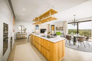 a kitchen with a sink and a table with chairs at Luxury 3-Bed Penthouse with Ocean Views, Terrace & Pool in Quarteira