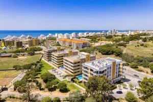 an aerial view of a city with buildings and the ocean at Luxury 3-Bed Penthouse with Ocean Views, Terrace & Pool in Quarteira