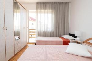 希貝尼克的住宿－Apartments by the sea Brodarica, Sibenik - 21441，一间卧室设有两张床和窗户。