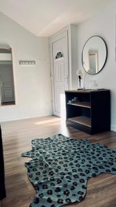 a living room with a mirror and a rug at RhizHome - Coeur de ville, appartement spacieux in Auxerre