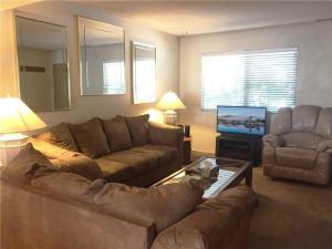 a living room with a couch and a tv at Summit Getaway Condo - Affordable and ideally located, Wood burning fireplace! Walk to Ski Resort in Big Bear Lake