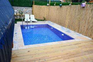 una piscina en un patio trasero con una valla de madera en VİLLA BUNGALOW en Kartepe