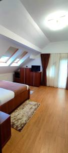a room with two beds and a television in it at Pensiunea Antonio Bran in Bran