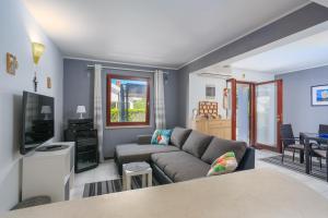 ein Wohnzimmer mit einem Sofa und einem TV in der Unterkunft Apartments with a parking space Njivice, Krk - 20542 in Njivice