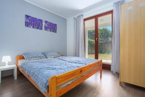 ein Schlafzimmer mit einem Bett und einem großen Fenster in der Unterkunft Apartments with a parking space Njivice, Krk - 20542 in Njivice