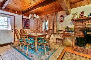 een eetkamer met een tafel en stoelen en een open haard bij Summit Escape B - Rustic cabin with a hot tub and barbecue! Wood fireplace! Walk to Slopes! in Big Bear Lake