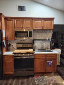 a kitchen with wooden cabinets and a stove and a sink at GCRetreat in Upland