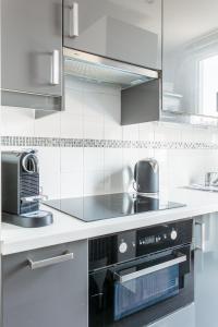 uma cozinha com um fogão e um micro-ondas em Auteuil Cozy Studio em Paris