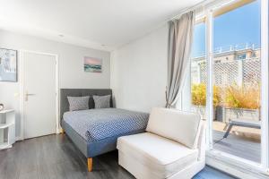 een slaapkamer met een bed, een stoel en een raam bij Auteuil Cozy Studio in Parijs