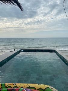una piscina con el océano en el fondo en La Soñadora casa frente al mar con piscina en Canoas