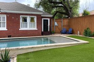 a swimming pool in a yard next to a house at Woodlawn Avenue Beauty in San Antonio