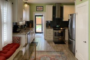 uma cozinha com armários brancos e um sofá vermelho em Woodlawn Avenue Beauty em San Antonio