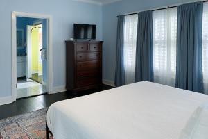 a bedroom with a bed and a dresser and a television at Woodlawn Avenue Beauty in San Antonio